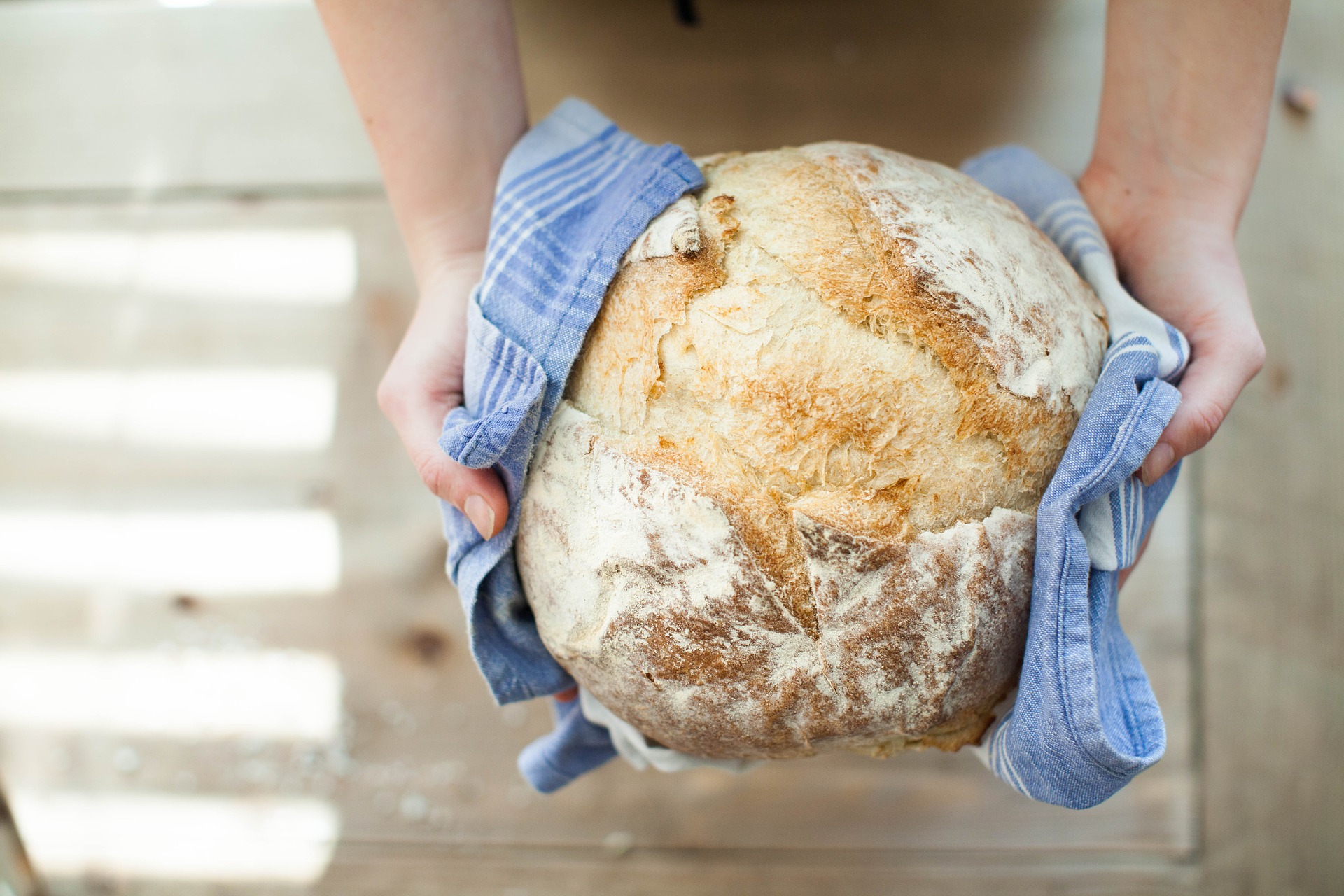 Persoană care ține în mână pâine fără gluten