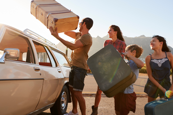 familie care împachetează valize în mașină înainte de o vacanță