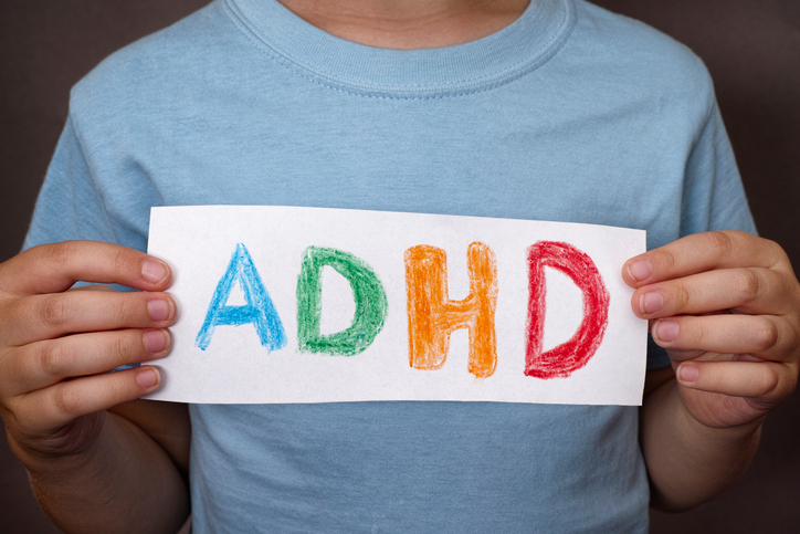 Un băiat ține o pancartă cu un semn colorat ADHD pe ea